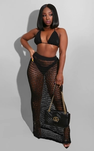 Detail of black crochet knit two-piece set featuring hollow mesh and side slit skirt