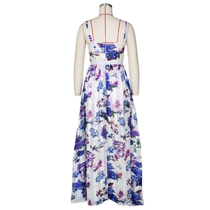 Détail d'une robe longue blanche à fleurs avec mousseline plissée et motifs floraux vifs