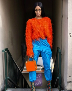 Détail rapproché du pull en maille duveteuse orange vif avec une texture pelucheuse