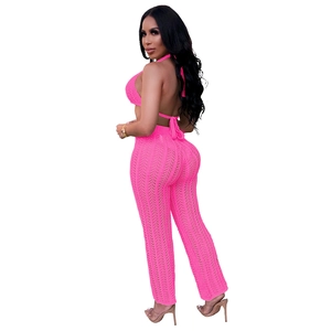 Detailed macro view of neon pink crochet hollow knit texture on high waist trousers