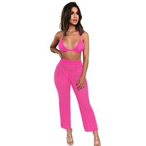 Detailed close-up of honeycomb knit texture on a bright pink crochet two-piece beach set
