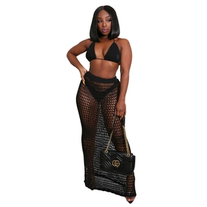 Detail of black crochet two-piece set featuring halter top and mesh maxi skirt textures