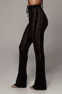 Détail du pantalon en maille crochet noir avec taille haute à cordon et motifs ajourés