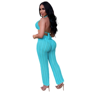 Close-up of turquoise crochet knit two-piece set featuring halter top and sheer trousers