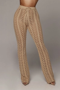 Gros plan détaillé du pantalon en maille crochet beige avec motifs géométriques ajourés