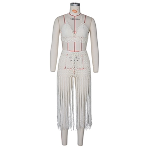 Detail eines weißen Häkel-Sets bestehend aus Neckholder-Bikini und Rock mit langen Fransen