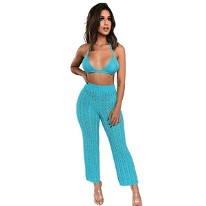 Detail of teal crochet knit texture on halter bikini top and hollow-out beach trousers