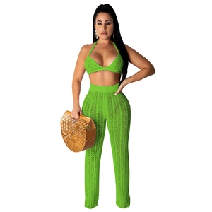 Detail of neon green crochet knit texture on beachwear halter top and hollow trousers