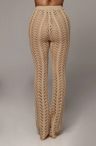 Détail macro du pantalon en maille crochet beige avec motif géométrique ajouré
