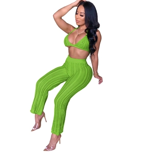 Detail view of green crochet knit bikini top and high-waisted hollow-out trousers
