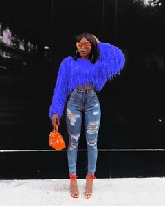 Détail du haut en tricot bleu roi avec de longues franges et un style urbain audacieux