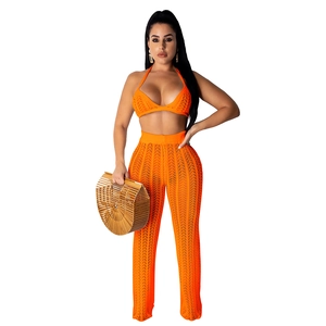 Detail of orange crochet knit two-piece set featuring hollow-out patterns and texture