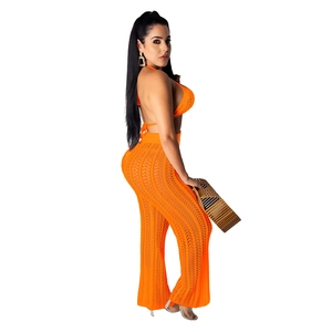 Detail of bright orange crochet knit crop top and high-waisted wide-leg sheer pants set