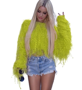 Détail d'un pull en maille à franges jaune fluo avec texture pelucheuse et glands longs