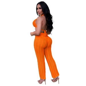 Detail of bright orange crochet two-piece set featuring hollow knit texture and beach style