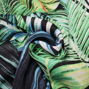 Détail du tissu à imprimé feuilles de palmier tropicales aux motifs verts et bleus