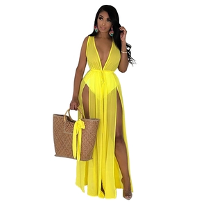 Détail du tissu en mousseline jaune transparent et de la fente haute de cette robe de plage