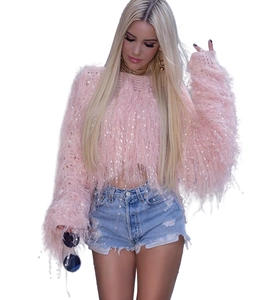 Détail d'un pull rose à manches longues avec franges denses et paillettes blanches