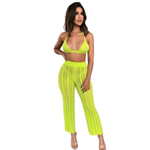Detail of neon yellow crochet knit two-piece set featuring halter top and wide-leg pants