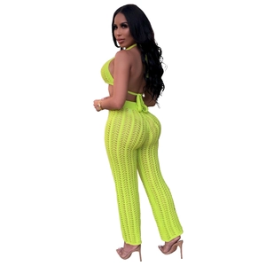 Detail of neon green crochet knit crop top and high-waisted wide-leg trousers