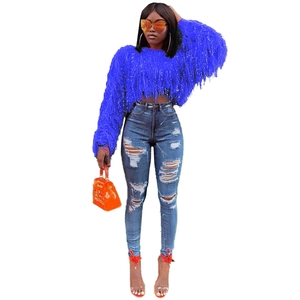 Détail d'un pull en maille bleu vif à manches longues avec des textures à franges