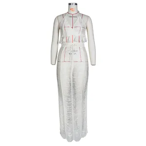 Detail view of white crochet knit two-piece set with tassel trim and hollow-out texture