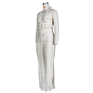 Detailed crochet texture of white two-piece beach set with tassels and high side slits