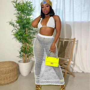 White crochet knit beach two-piece set featuring halter bikini top and hollow mesh long skirt