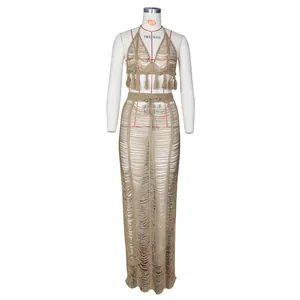 Detailed knit texture of a two-piece beach set featuring fringe crop top and maxi skirt