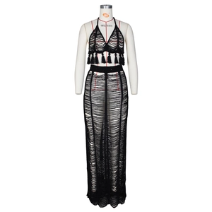 Detailed close-up of black crochet hollow-out knit two-piece beach set with long tassels