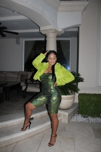 Detail shot of the neon green faux fur jacket with shimmering sequin romper set