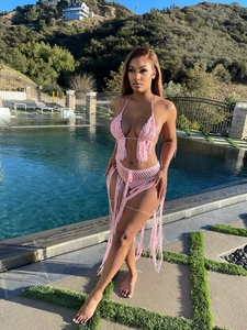 Details des rosa handgehäkelten Bikini-Sets mit langen Fransen an einem Außenpool