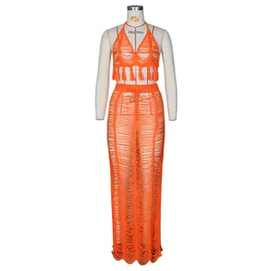 Detailed view of orange crochet knit two-piece set featuring cutout texture and fringe tassels