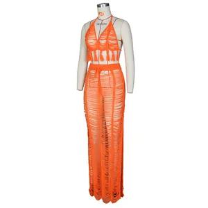 Detailed knit texture and tassels of an orange crochet two-piece beach skirt set