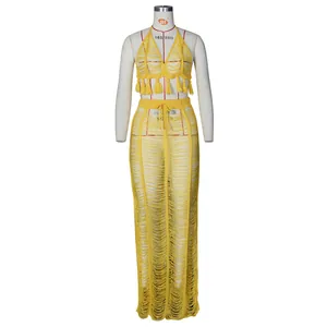 Detail of yellow knit beach set showing crochet hollow patterns and long fringe hem