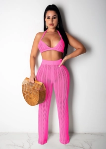 Detail of neon pink crochet two-piece set featuring halter top and hollow out knit pants