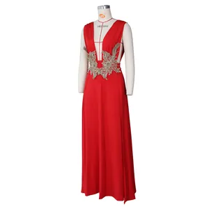 Détail d'une robe de soirée rouge avec d'élégantes broderies florales dorées à la taille