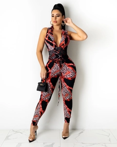 Detail of V-neck jumpsuit featuring red chain and leopard print with waist tie design