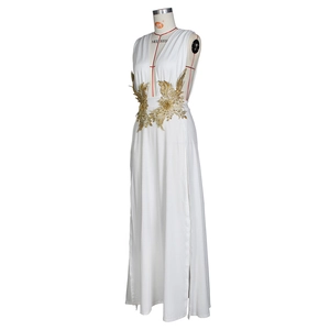 Détail d'une robe de soirée blanche à décolleté en V plongeant et broderies dorées à paillettes