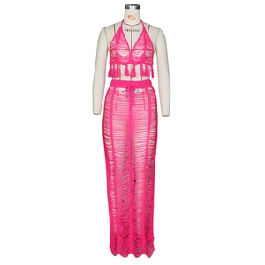 Detail of rose red crochet beach set showing tassel hem and hollow knit texture