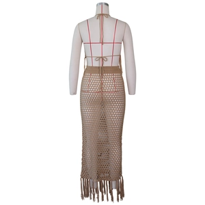 Détails de la maille au crochet et des longues franges sur le bas de la jupe longue beige