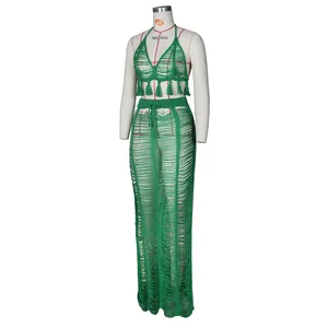 Close-up of green crochet knit beach set featuring tassel hem and hollow-out stripe texture