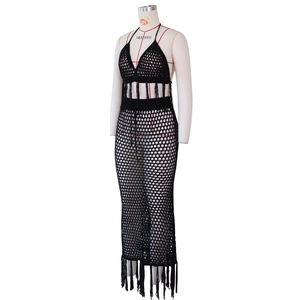 Détail d'un ensemble en crochet noir avec maille ajourée et pompons faits à la main