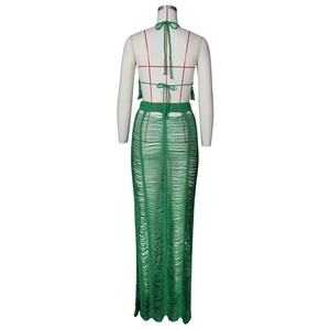 Detail of green crochet two-piece set featuring hollow-out knit texture and fringe design