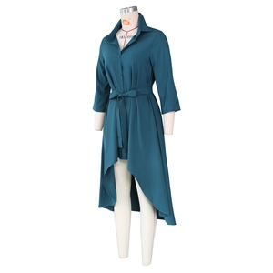 Detail of high-low hem and waist tie on the dark teal asymmetrical shirt dress