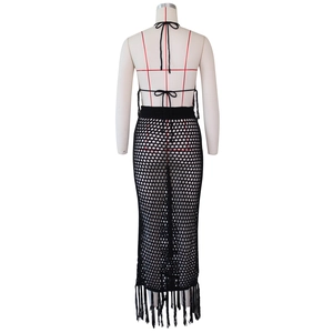 Détail de la robe de plage en crochet noir avec maille ajourée et longues franges