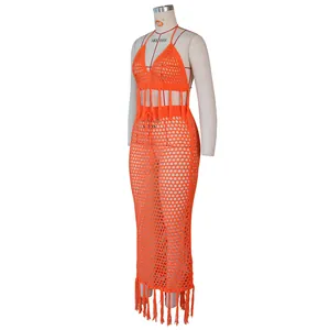 Détail d'un ensemble en crochet orange avec de longues franges et maille ajourée