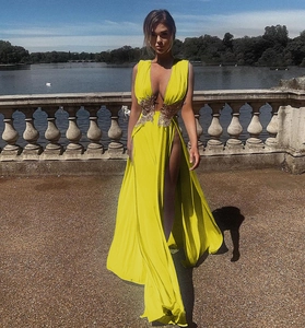 Détail de la robe de soirée jaune vif avec broderie dorée et fente haute sur la jambe