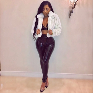 Detail of white faux fur jacket paired with high-gloss black patent leather pants