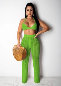 Detail of neon green crochet knit crop top and wide leg pants with hollow wave pattern